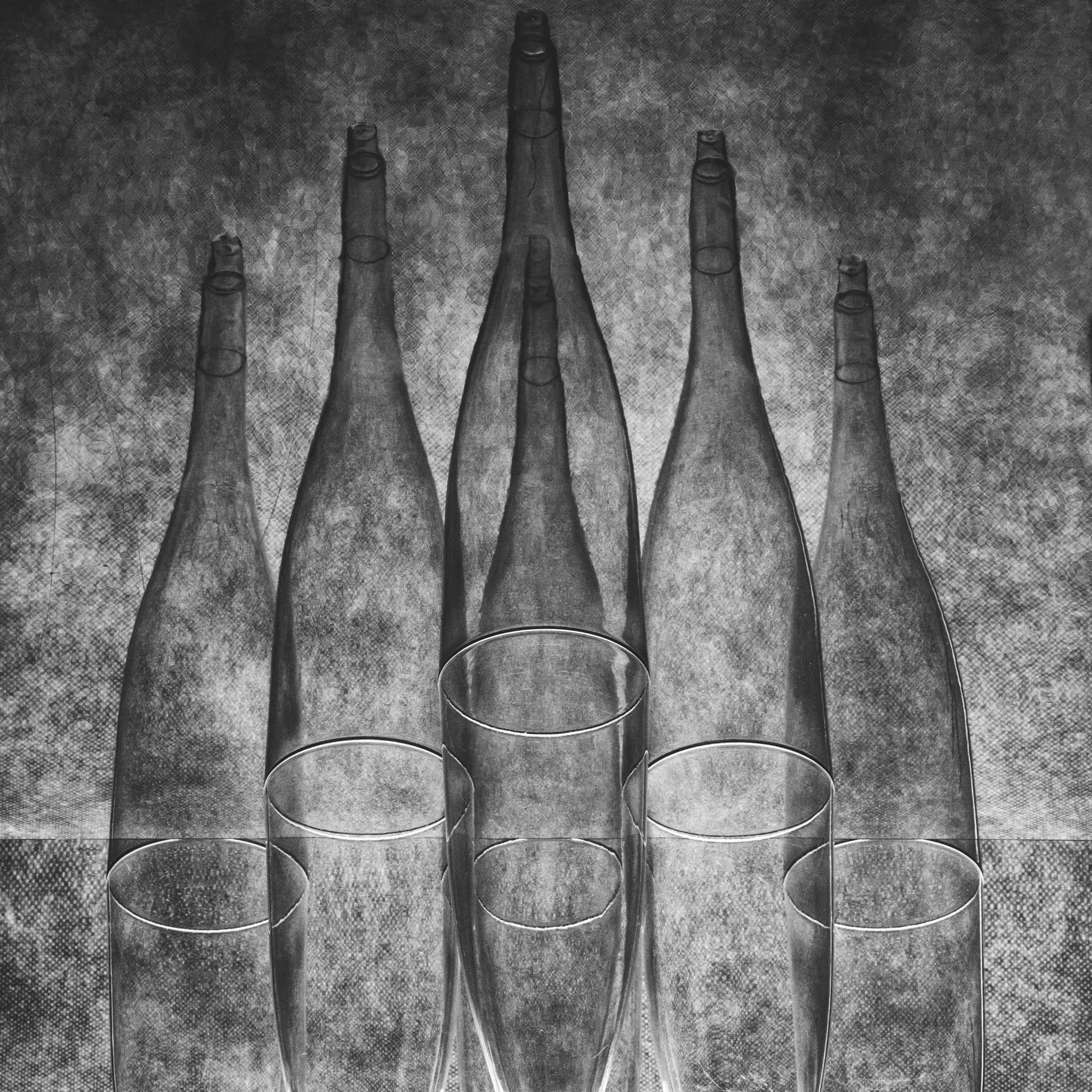 Editorial still life of glass and brushed steel on seamless black, one hard key, clean specular roll